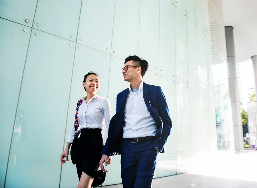 Asian business people discussing while walking