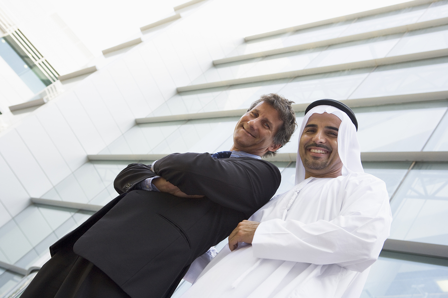 Two businessmen standing outdoors by building (high key/selective focus)