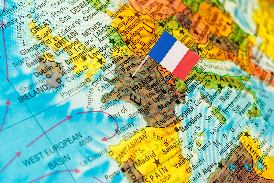 map with miniature flag of France .Selective focus on French Flag. Backlit lighting